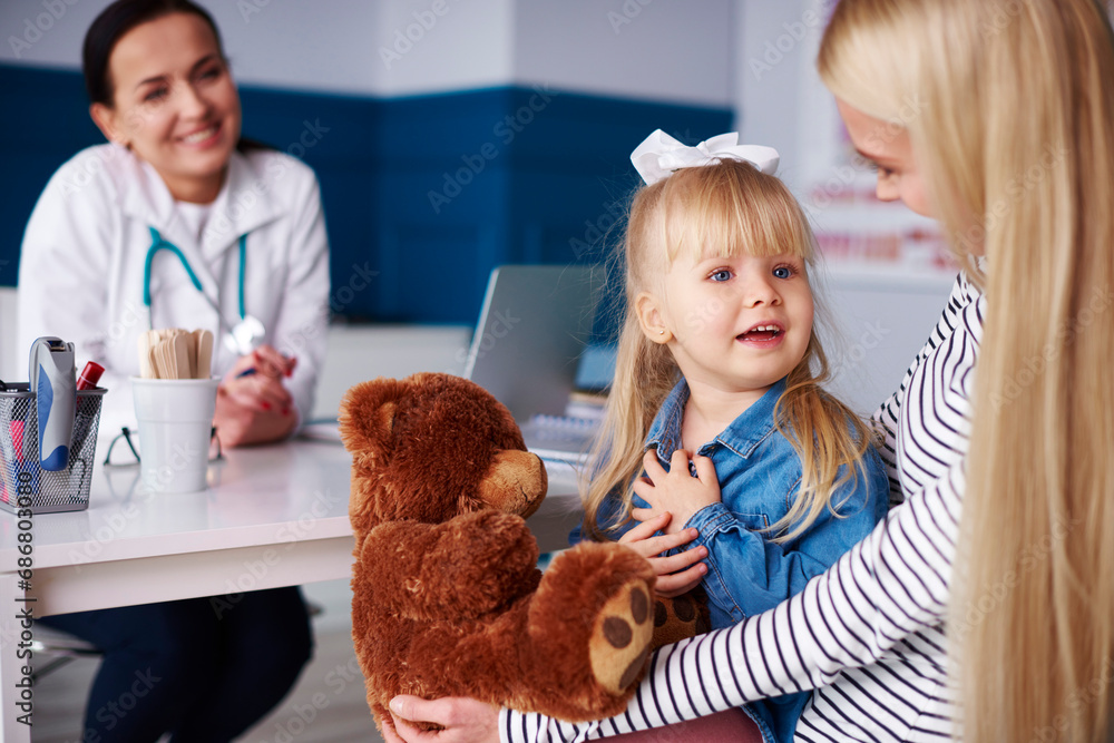 Mother with girl and teddy in medical practice