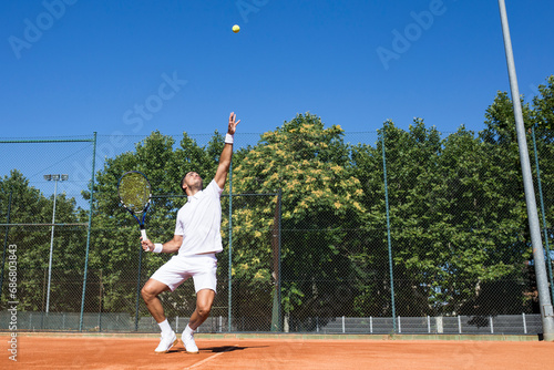 Tennis player serving a tennis ball during a tennis match