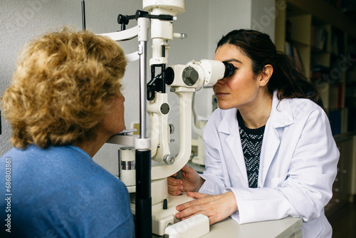 Fototapeta Naklejka Na Ścianę i Meble -  Ophthalmologist examining eyesight of a senior patient