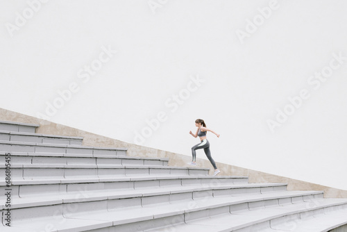 Young woman running on concrete bleachers