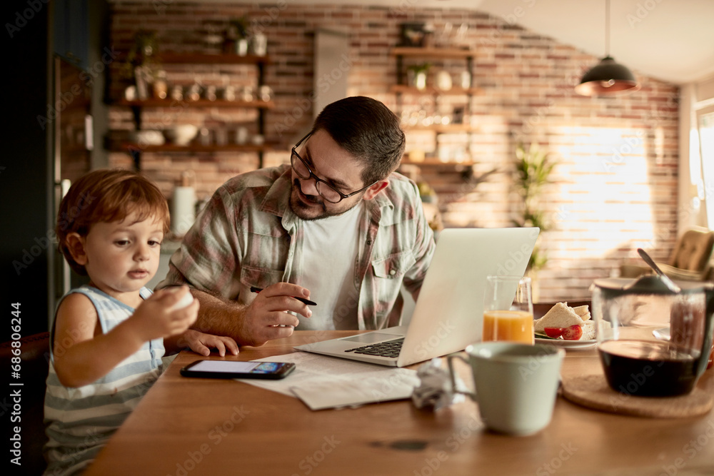 © Davor - Father and Son Spending Quality Time Together at Home with Laptop