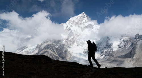 Woman trekking with Mt Everest, Nuptse and Kala Patthar in background, Himalayas, Solo Khumbu, Nepal © tunedin