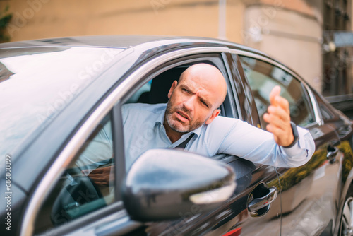 Businessman driving car and looking angry