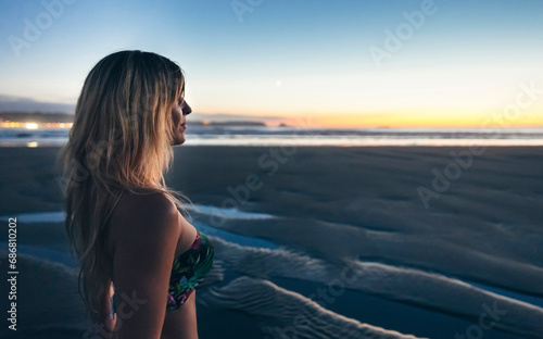 Young woman watching the sunset on the beach