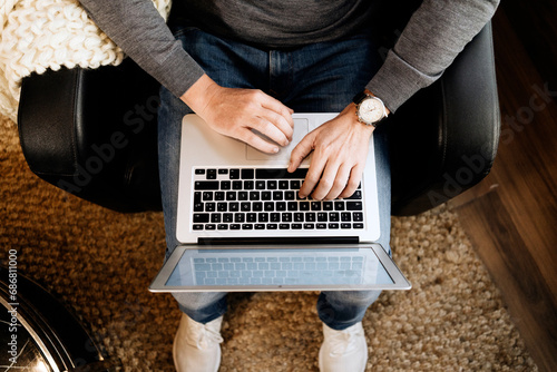 Man sitting at home, using laptop, close-up photo