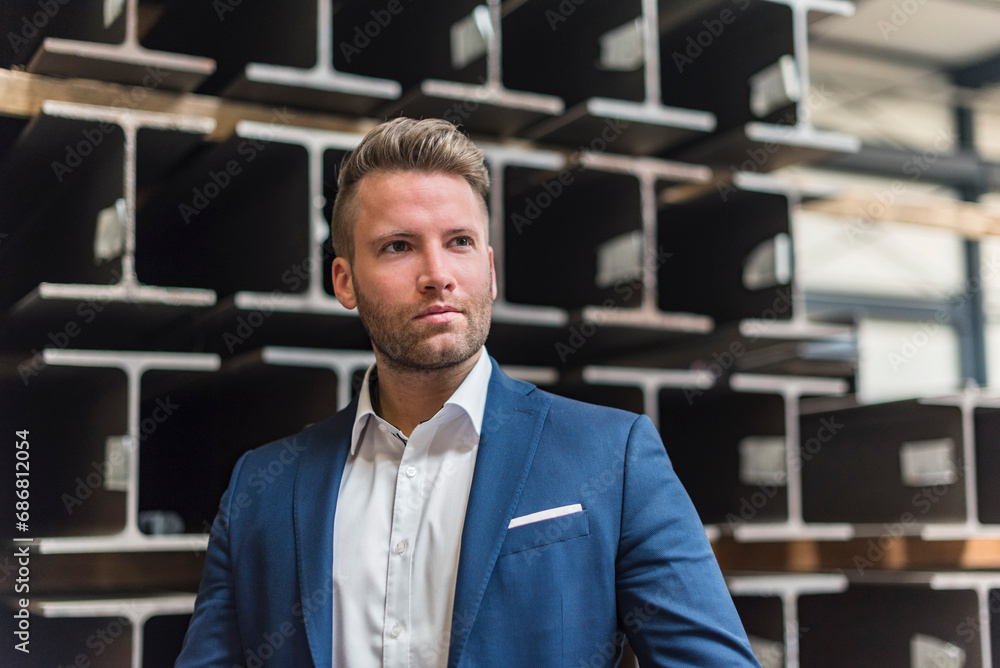Portrait of confident businessman on factory shop floor looking around