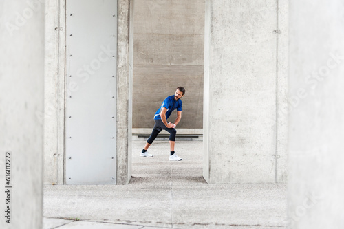 Man stetching at an underpass