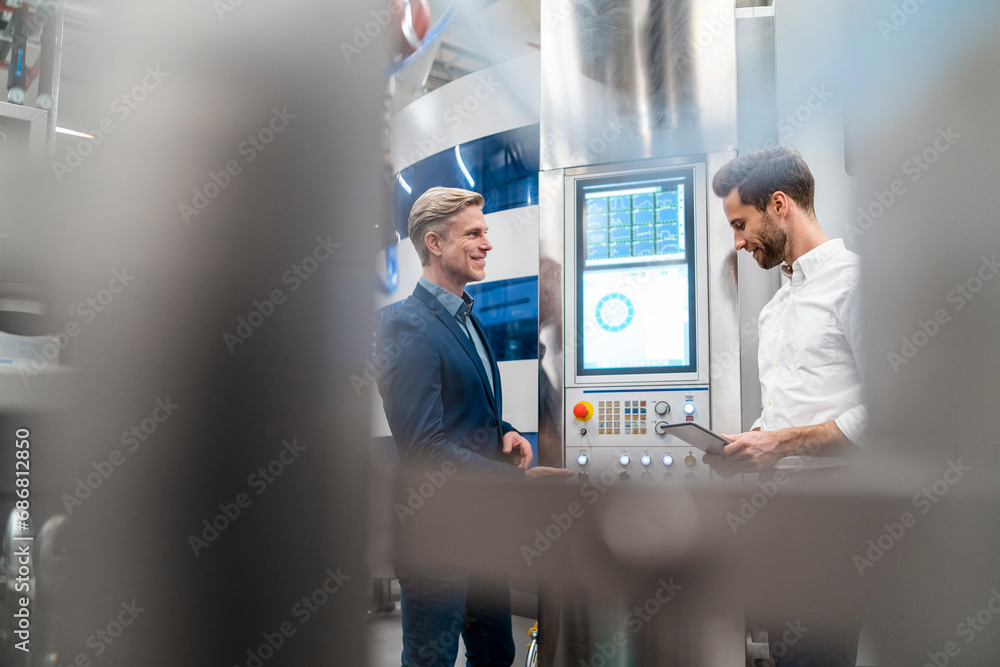 Two businessmen talking in a modern factory