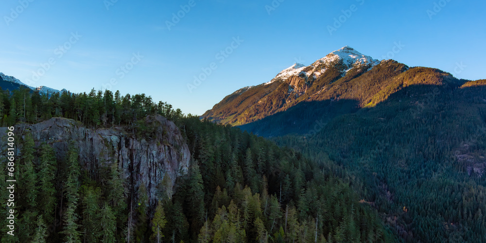 Canadian Mountain Landscape, rocks with green trees and snow on top