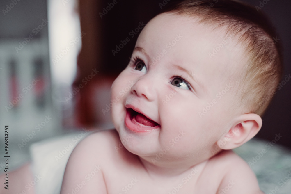 Close-up of cute shirtless baby girl looking away at home Close-up of cute shirtless baby girl looking away at home