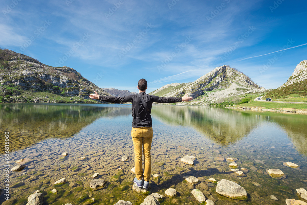 Spain, Asturias, Picos de Europa National Park, man standing with raised arms at Lakes of Covadonga Spain, Asturias, Picos de Europa National Park, man standing with raised arms at Lakes of Covadonga