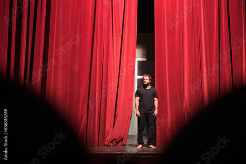Barefoot actor standing on theatre stage