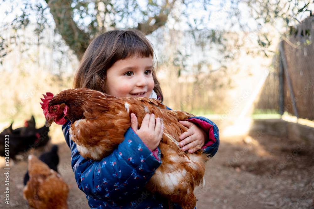 Portrait of smiling toddler girl holding chicken