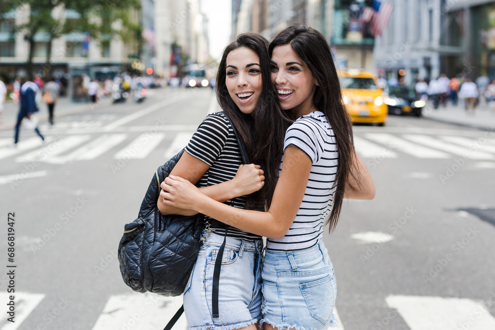 USA, New York City, two happy twin sisters in Manhattan