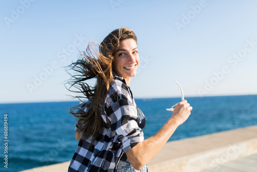 Young pretty woman wearing beach wear wlaking by the sea photo