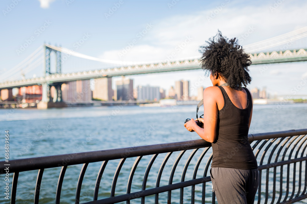 USA, New York City, Brooklyn, woman standing at the waterfront