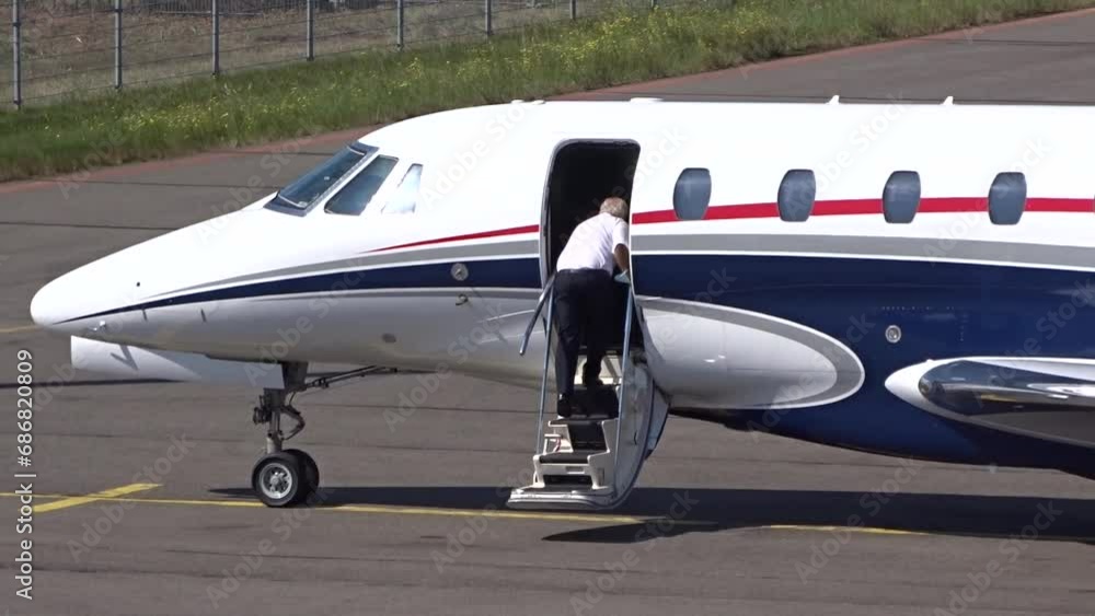Executive Jet with Pilot boarding the airplane at Small Airport (Business private jet corporate jet) Executive Jet with Pilot boarding the airplane at Small Airport (Business private jet corporate jet)