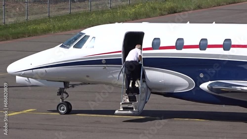 Executive Jet with Pilot boarding the airplane at Small Airport (Business   private jet   corporate jet) photo