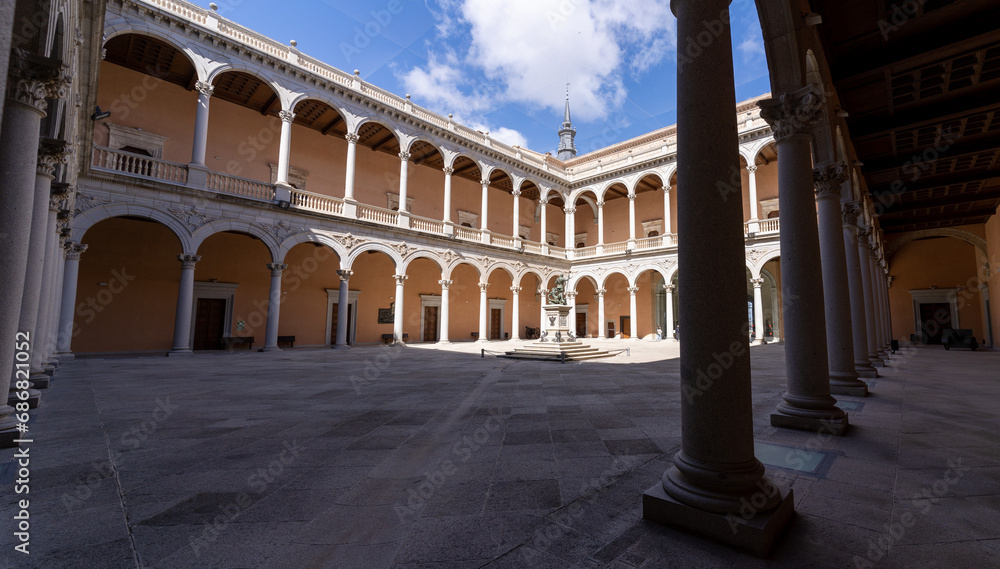 Low angle view of the empty cloister without people of the Alcázar of Toledo, Spain, with blue sky
