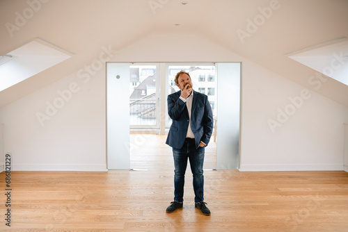 Businessman standing in empty apartement looking around