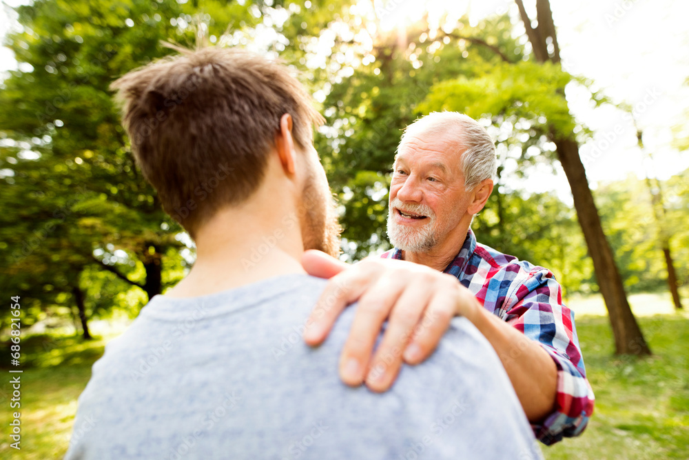 Happy senior father and his adult son in a park Happy senior father and his adult son in a park