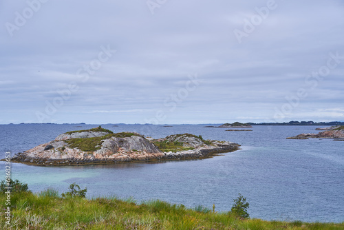 Wild but beautiful coast of Norwegian sea on the island Otroya in Norway close to city Midsund. Nice place with clean scandinavian nature without people, picture is taken in cloudy summer afternoon.