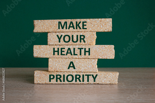 Concept green words Make your health a priority on brick blocks on a beautiful green background. Psychological mental health concept.