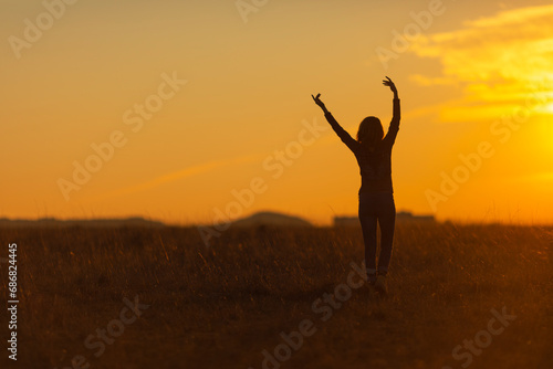 Woman walking in nature at sunset