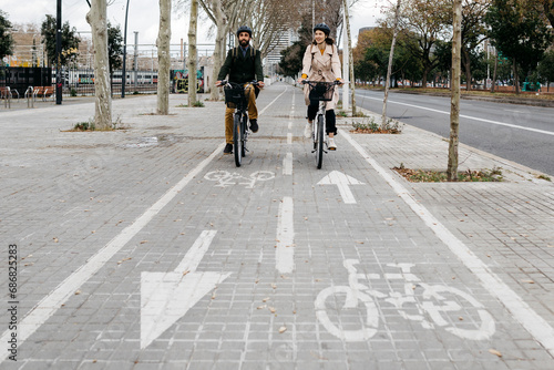 Couple riding e-bikes in the city on bicycle lane photo