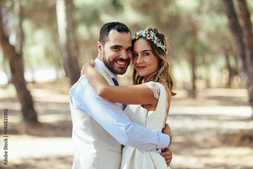 Portrait of happy bridal couple standing head to head in pine forest Portrait of happy bridal couple standing head to head in pine forest