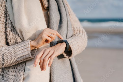 Woman on the beach checking her smartwatch photo