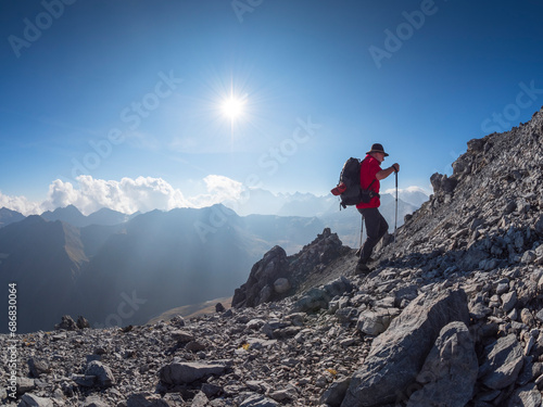 Border region Italy Switzerland, senior man hiking in mountain landscape at Piz Umbrail photo