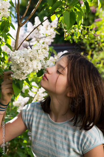 Portrait of girl smelling blossom of white lilac