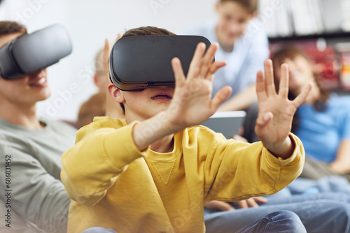 Little boy playing with VR goggles, sittiing on couch with his family photo