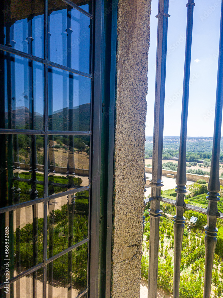 Fototapeta premium A regular park in the castle through a window with a metal grille