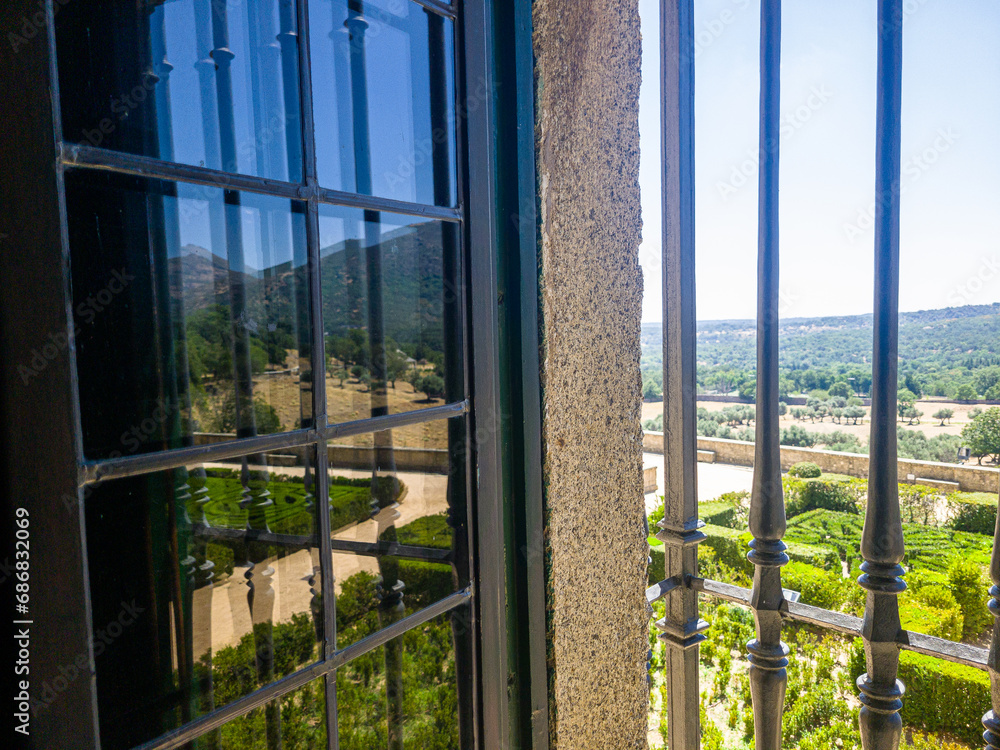 A regular park in the castle through a window with a metal grille A regular park in the castle through a window with a metal grille