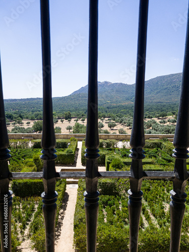 A regular park in the castle through a window with a metal grille