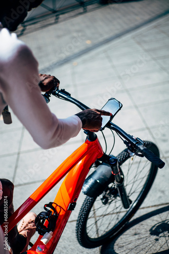 Bicycle courier using smartphone on handlebar