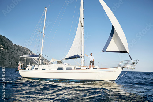 Mature man standing on his sailing boat looking at distance