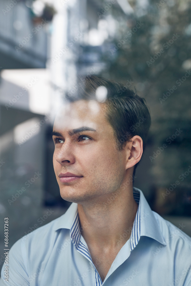 Portrait of young businessman behind glass pane in office Portrait of young businessman behind glass pane in office