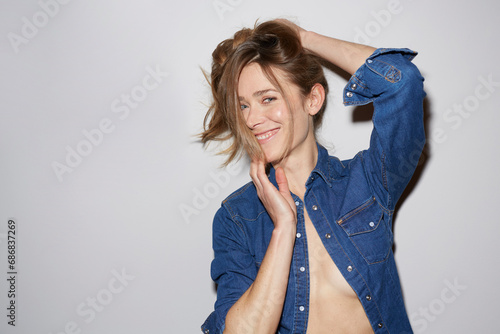 Portrait of laughing woman wearing fully unbuttoned denim shirt photo