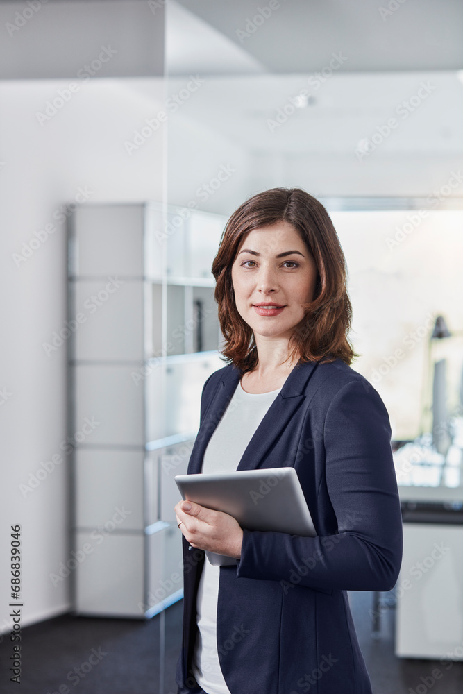 Portrait of smiling young businesswoman with tablet in office