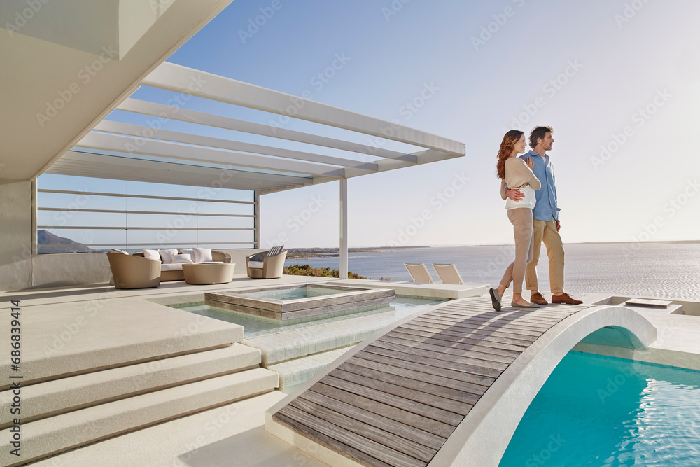 Couple standing on bridge above a swimming pool enjoying the view