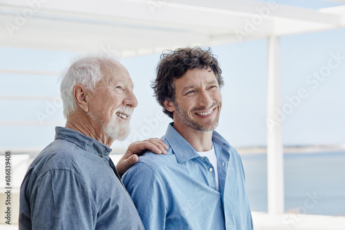 Portrait of confident senior man with adult son at a beach house photo