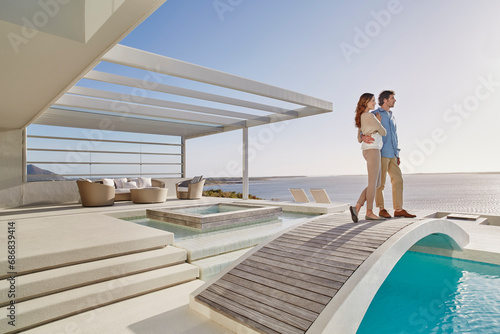 Obraz na płótnie Couple standing on bridge above a swimming pool enjoying the view w salonie