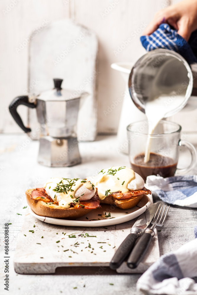 Traditional egg benedict with slices of bacon on toast, poached egg and hollandaise Traditional egg benedict with slices of bacon on toast, poached egg and hollandaise