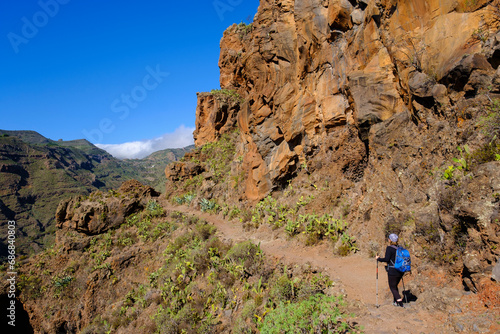 Spain, Province of Santa Cruz de Tenerife, SanSebastiandeLa Gomera, Rear view of senior backpacker hiking at Alto de Tacalcuse