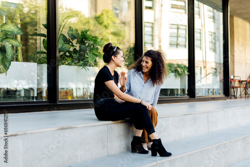 Two friends sitting on steps, gossipping