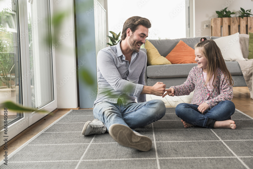 Young man and little girl sitting at home, playing paper scissors stone Young man and little girl sitting at home, playing paper scissors stone