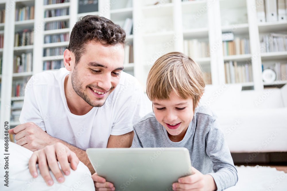 Father and son using tablet at home Father and son using tablet at home